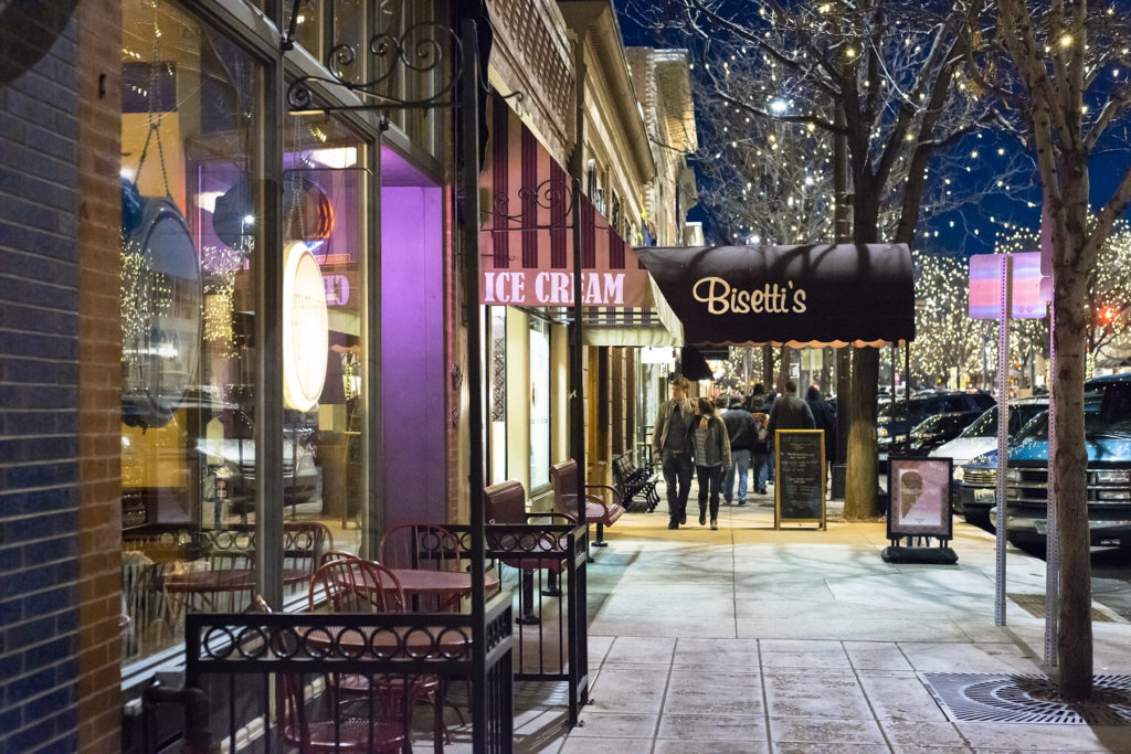 Fort Collins, Colorado, USA - February 2, 2013: People walking down South College Avenue, the main street of Fort Collins, Colorado at night. Situated at the foot of the Rocky Mountains, Fort Collins is a college town with a thriving downtown and has been voted by Money magazine to be one of the best towns to live in.